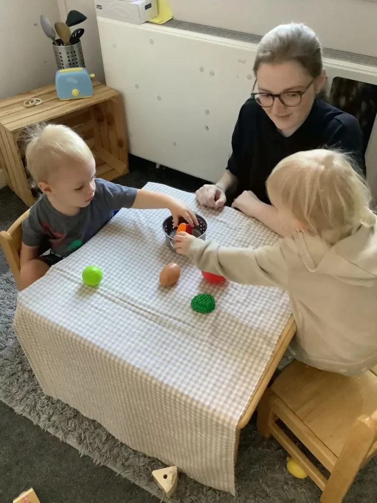 Kids playing together with a nursery carer