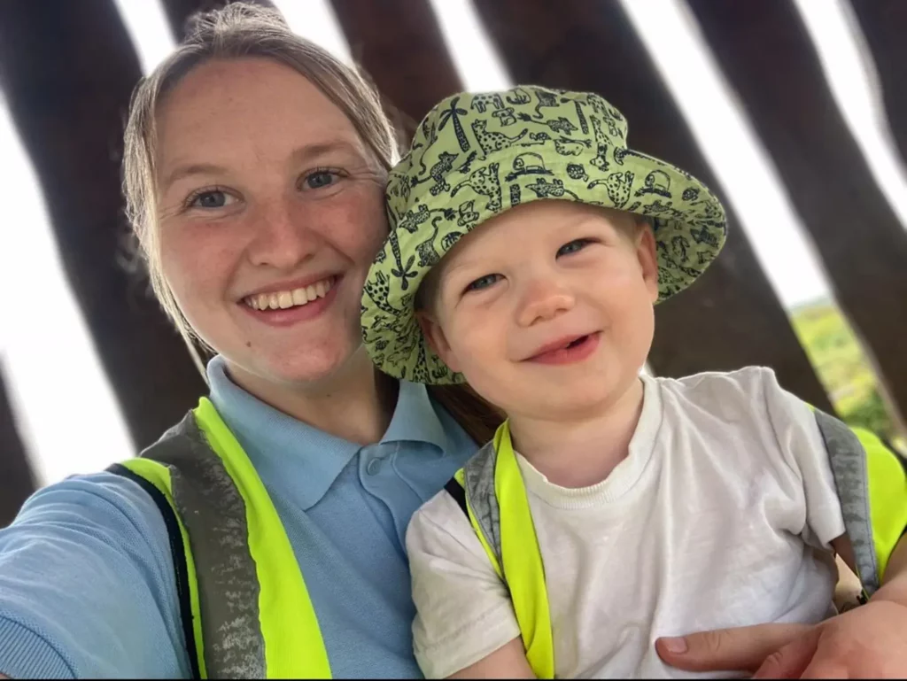 A child and a member of staff smiling